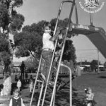 "One of two recovered photographs from the Stirling City Library blaze. Notable for being taken the day which fourteen children vanished and for what is referred to as “The Slender Man”. Deformities cited as film defects by officials. Fire at library occurred one week later. Actual photograph confiscated as evidence. – 1986, photographer: Mary Thomas, missing since June 13th, 1986."